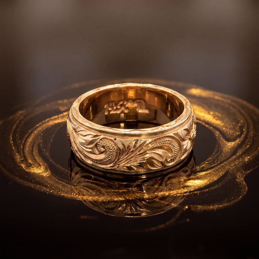 Wide yellow gold band ring with floral and scroll engraving between polished edges