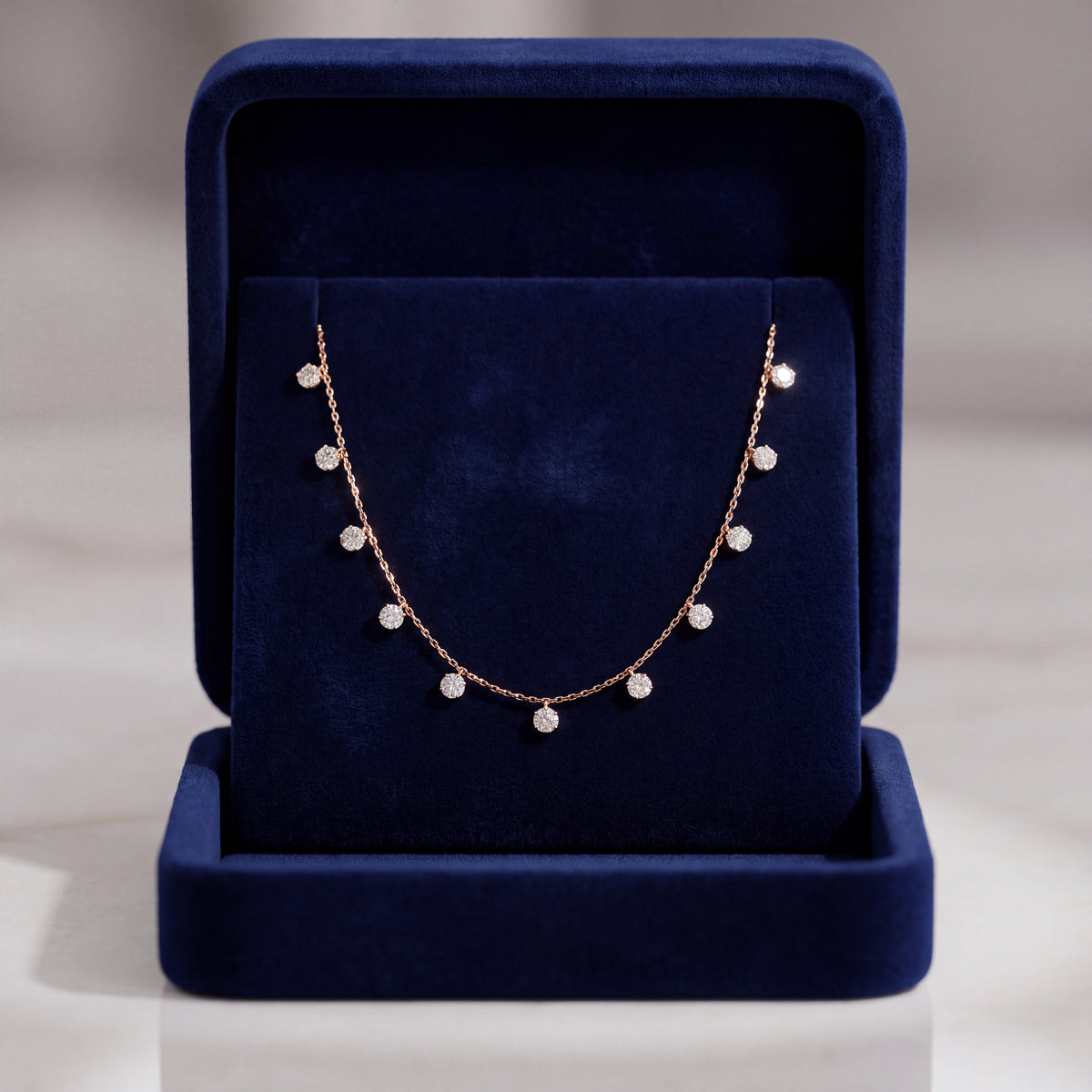 Yellow gold necklace with round diamond drops spaced along the chain