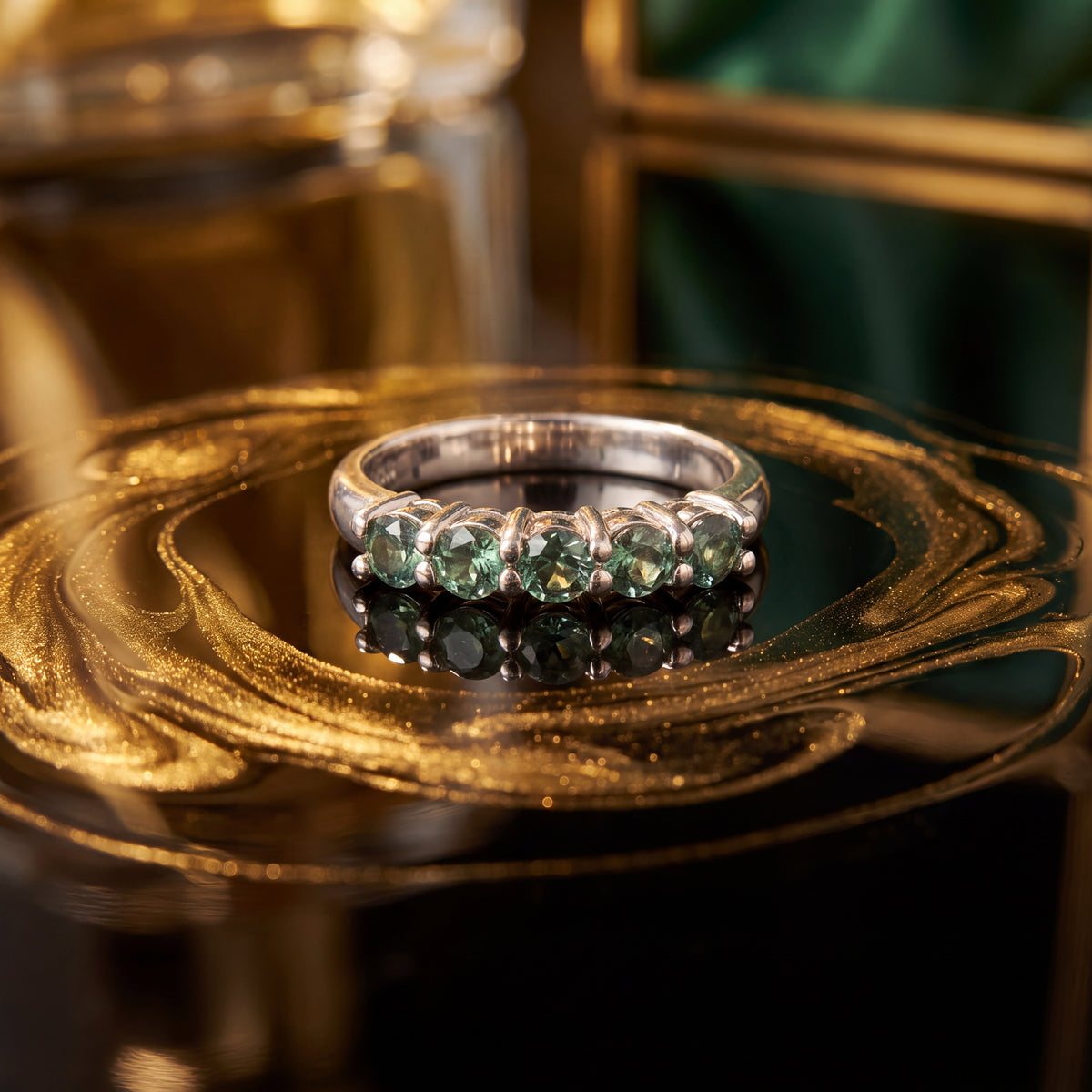 White gold ring with a row of five round alexandrite gemstones in prong settings