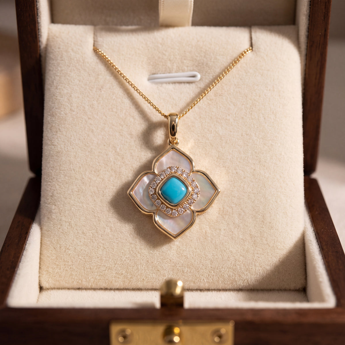 Yellow gold quatrefoil pendant with a turquoise cabochon in a diamond halo over mother of pearl inlay