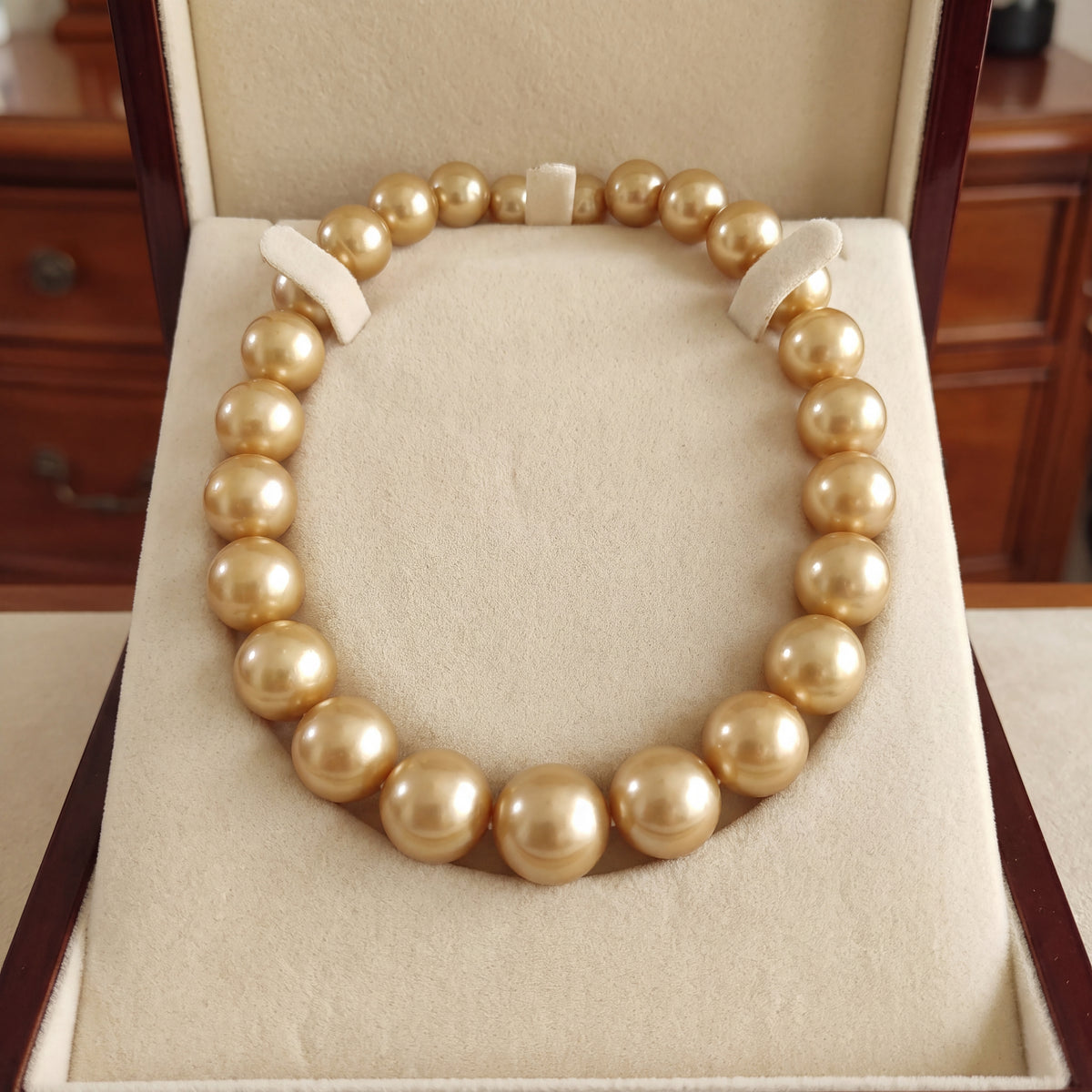 Necklace strand of round golden pearls