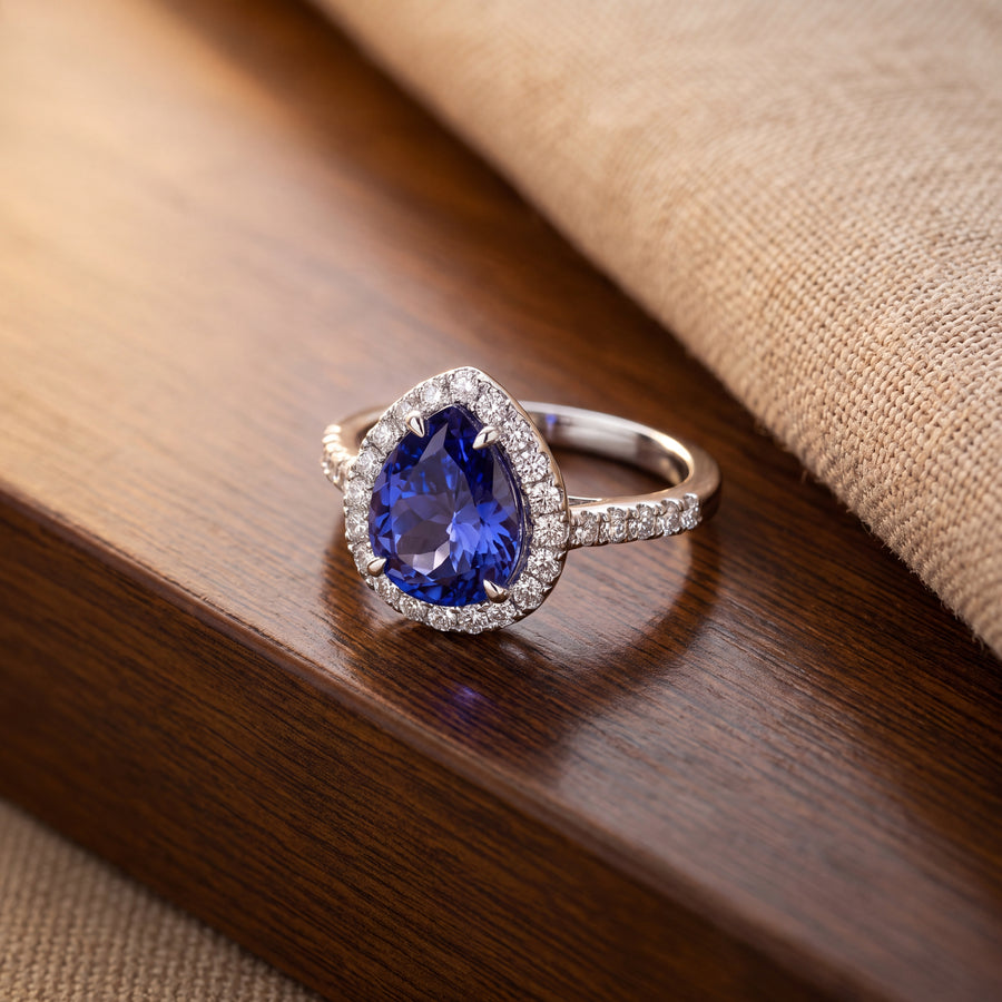 Pear-shaped tanzanite in a diamond halo on a slender band