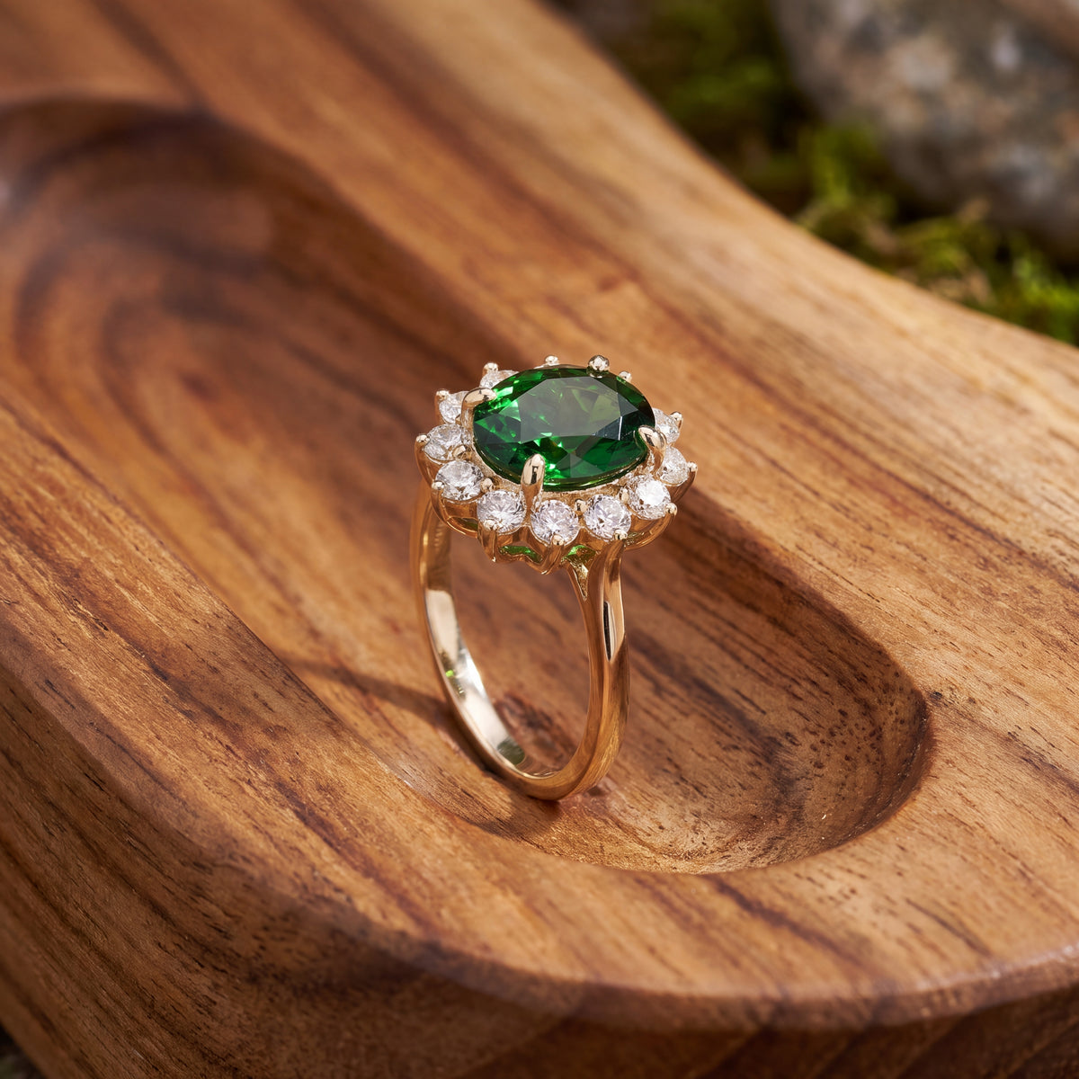 Oval green gemstone in a diamond halo on a yellow gold band