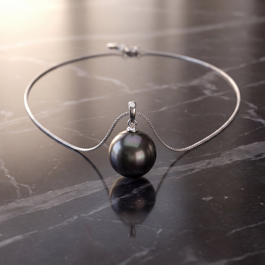 Single dark round pearl pendant on a white gold chain