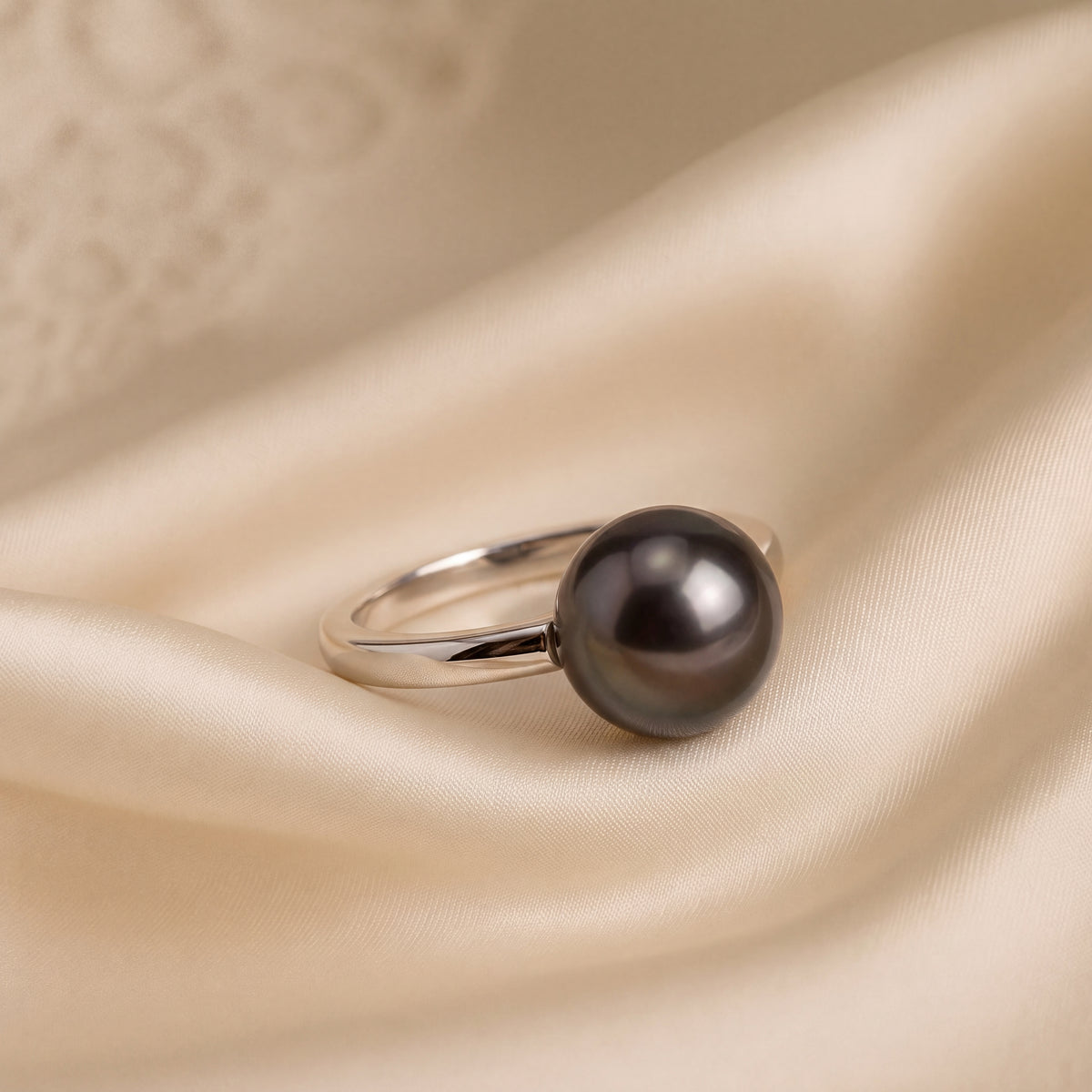 Solitaire ring with a single dark pearl on a plain band