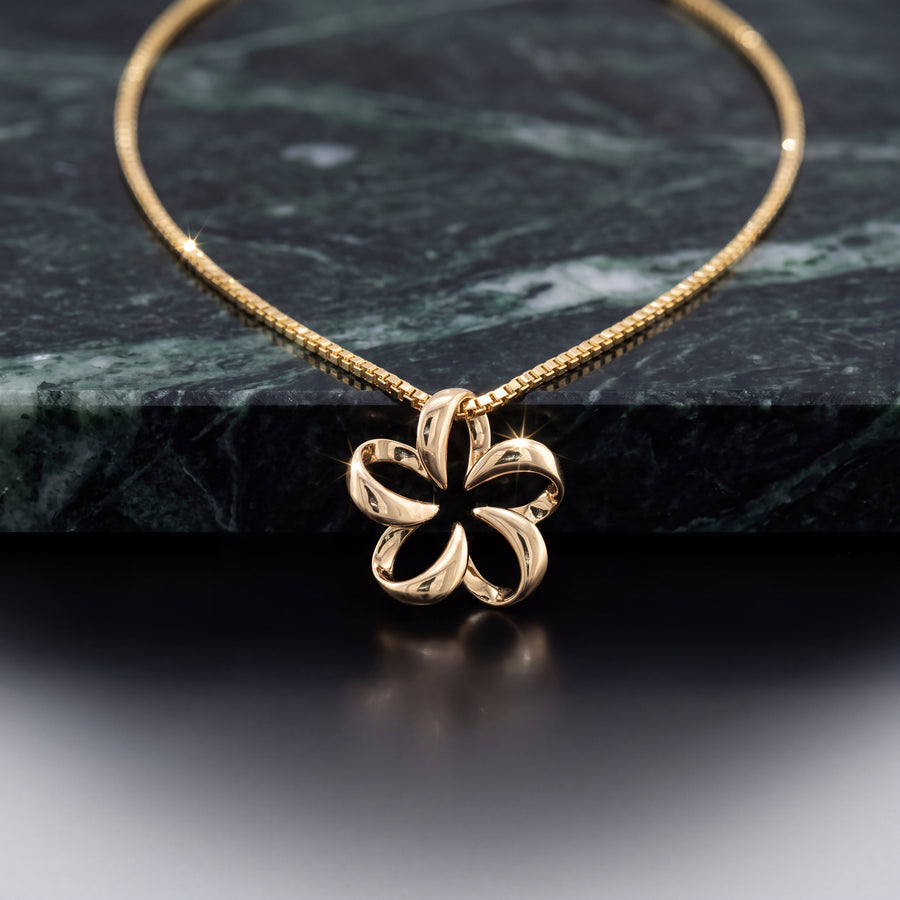 A yellow gold open-petal flower pendant on a fine chain.