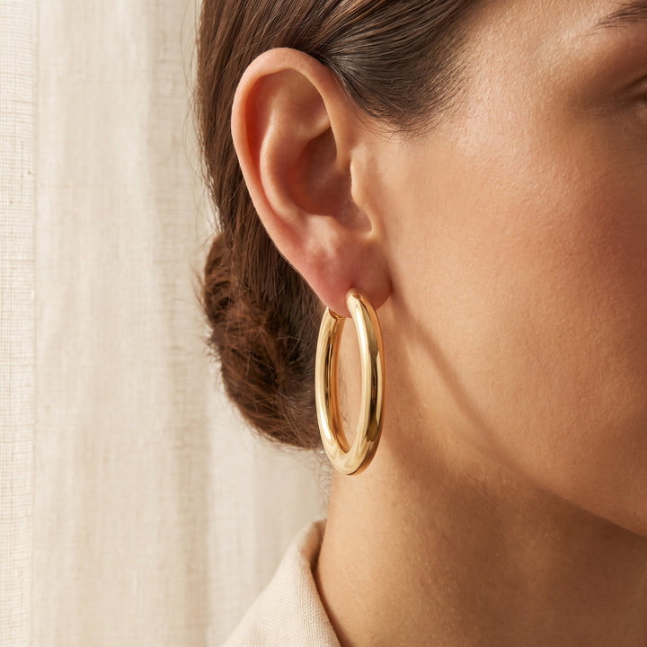 Classic Polished Tubular Hoop Earrings in 14K Yellow Gold, worn