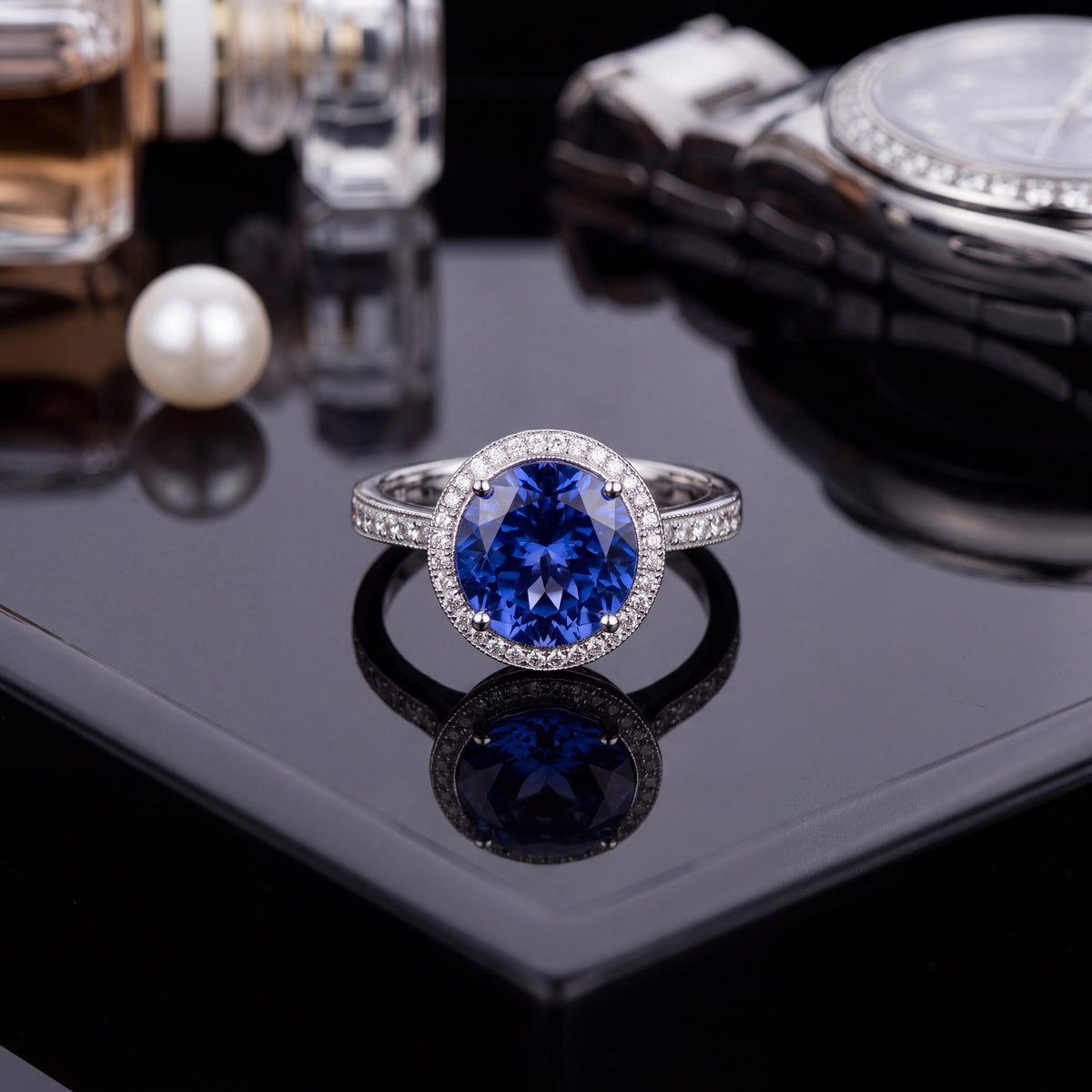 Round tanzanite in a diamond halo with diamond shoulders, on a black tray