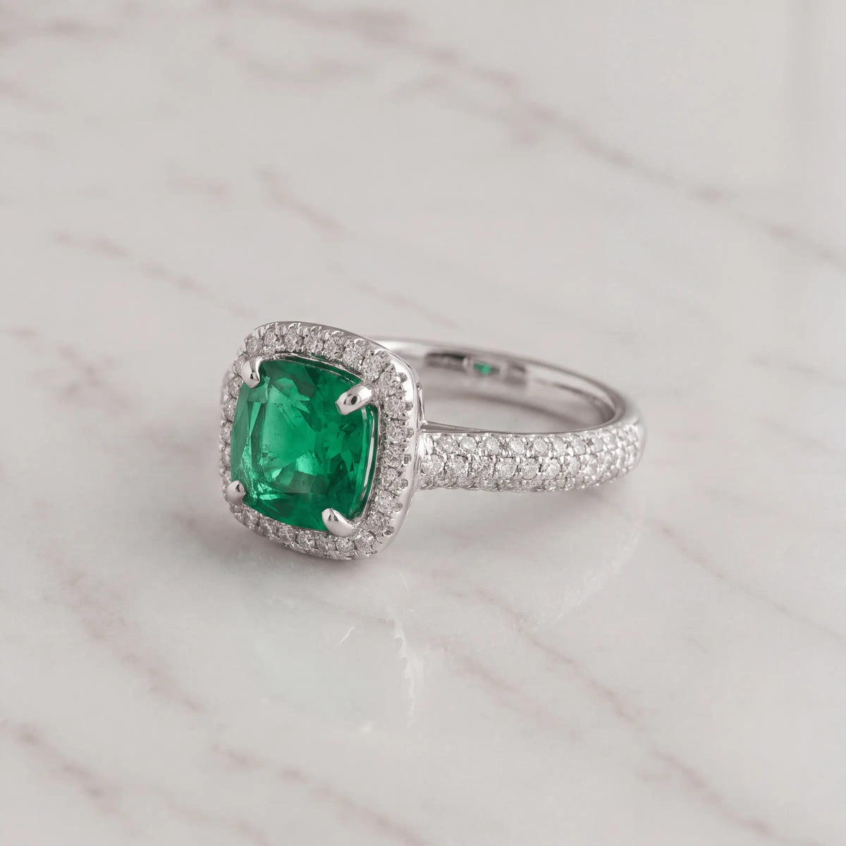 A green-center ring with a diamond band on pale marble