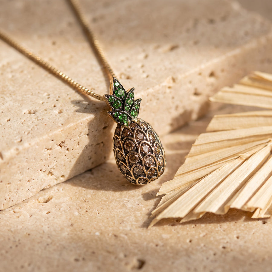 Yellow gold pineapple pendant with cognac diamonds on the scalloped body and a tsavorite crown