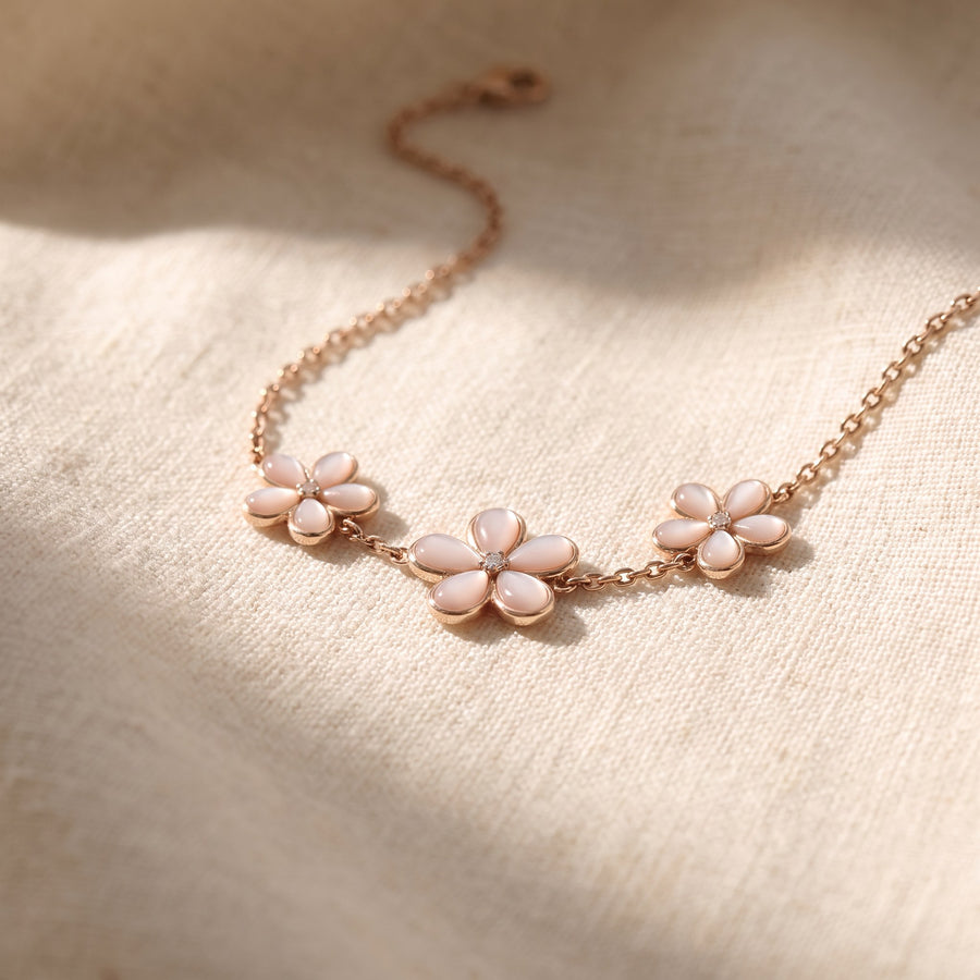 Rose gold chain bracelet with three small pale pink flowers