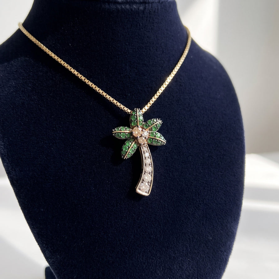 Yellow gold palm tree pendant with green-stone fronds and a row of white stones down the trunk