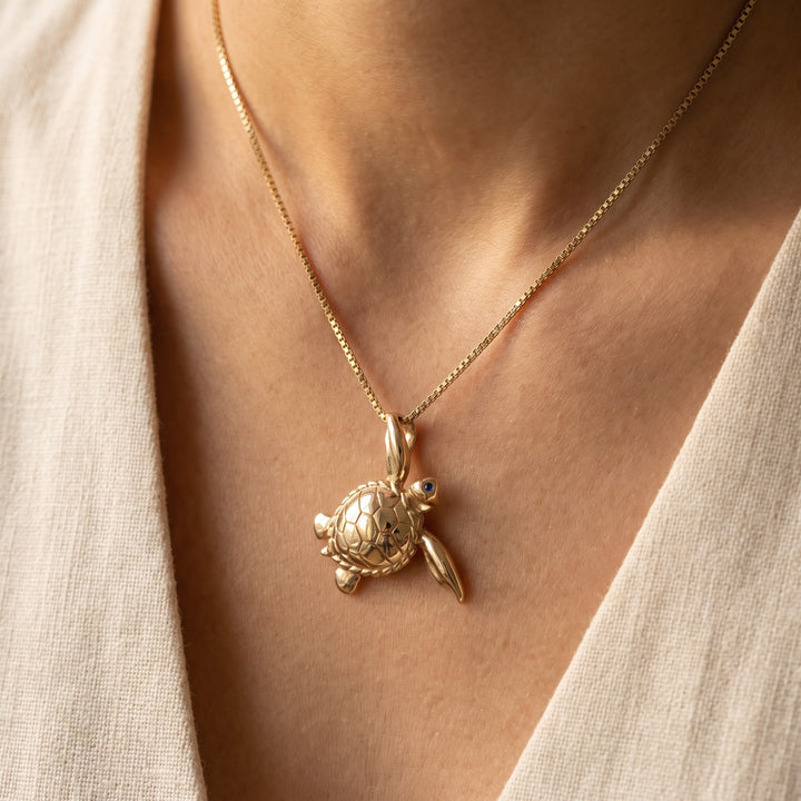 Mother of Pearl Inlay and Blue Sapphire Turtle Charm Necklace in 14K Yellow Gold, worn