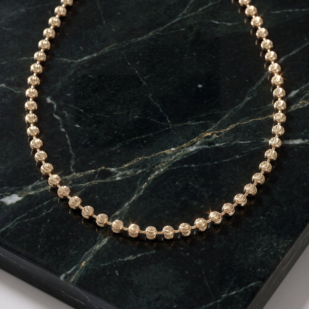 Yellow gold chain of faceted round beads