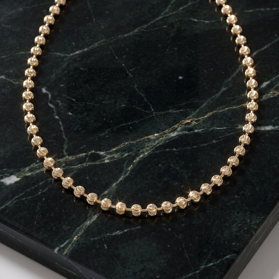 Yellow gold chain of faceted round beads