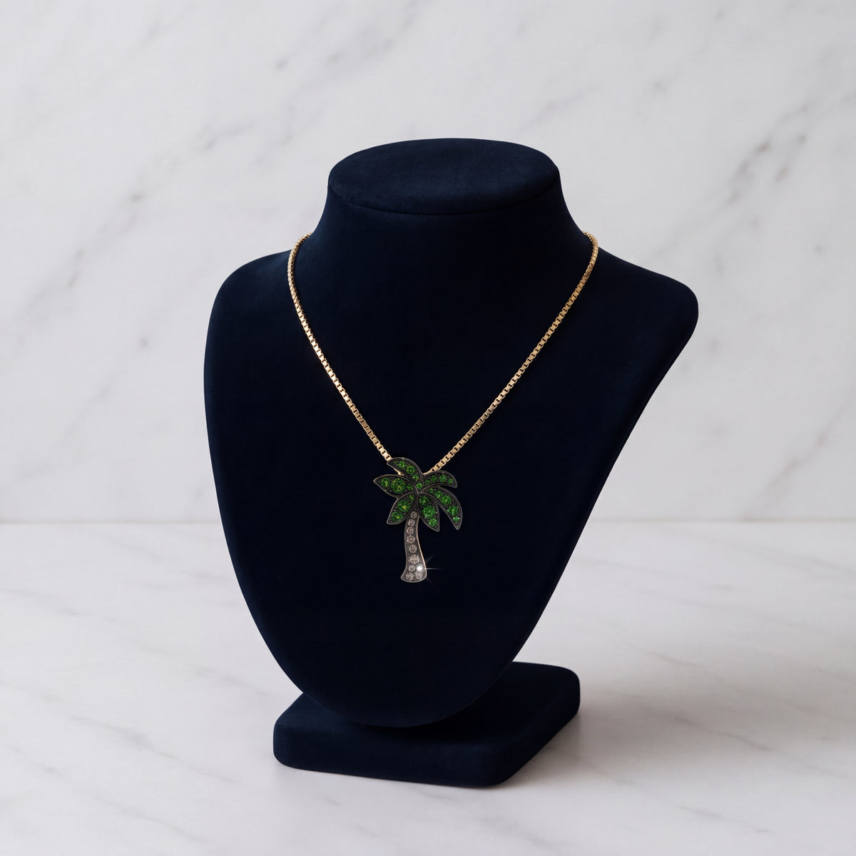 Palm tree pendant set with green stones through leaves and trunk
