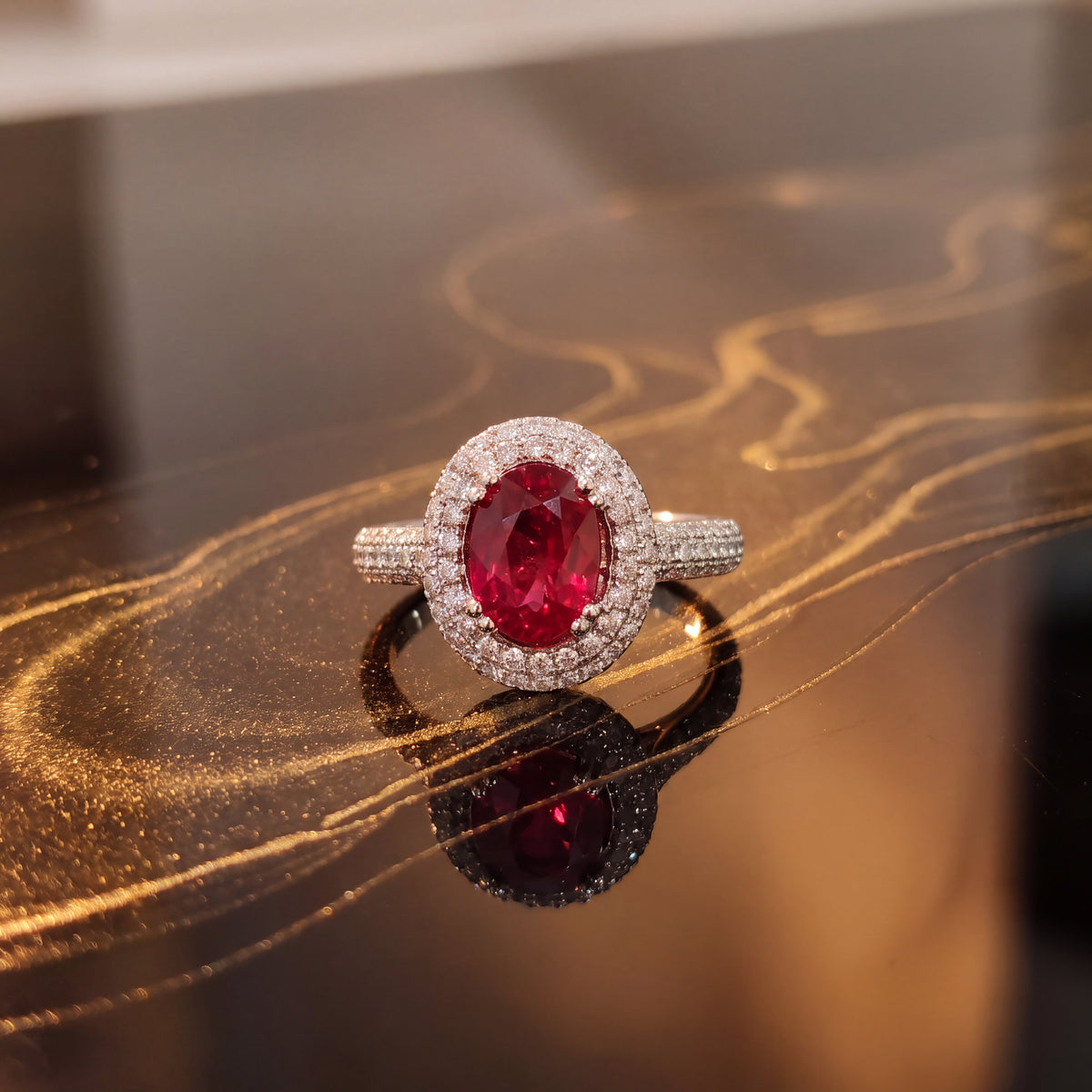 Oval red ruby in a double diamond halo on a pavé band, on dark glass
