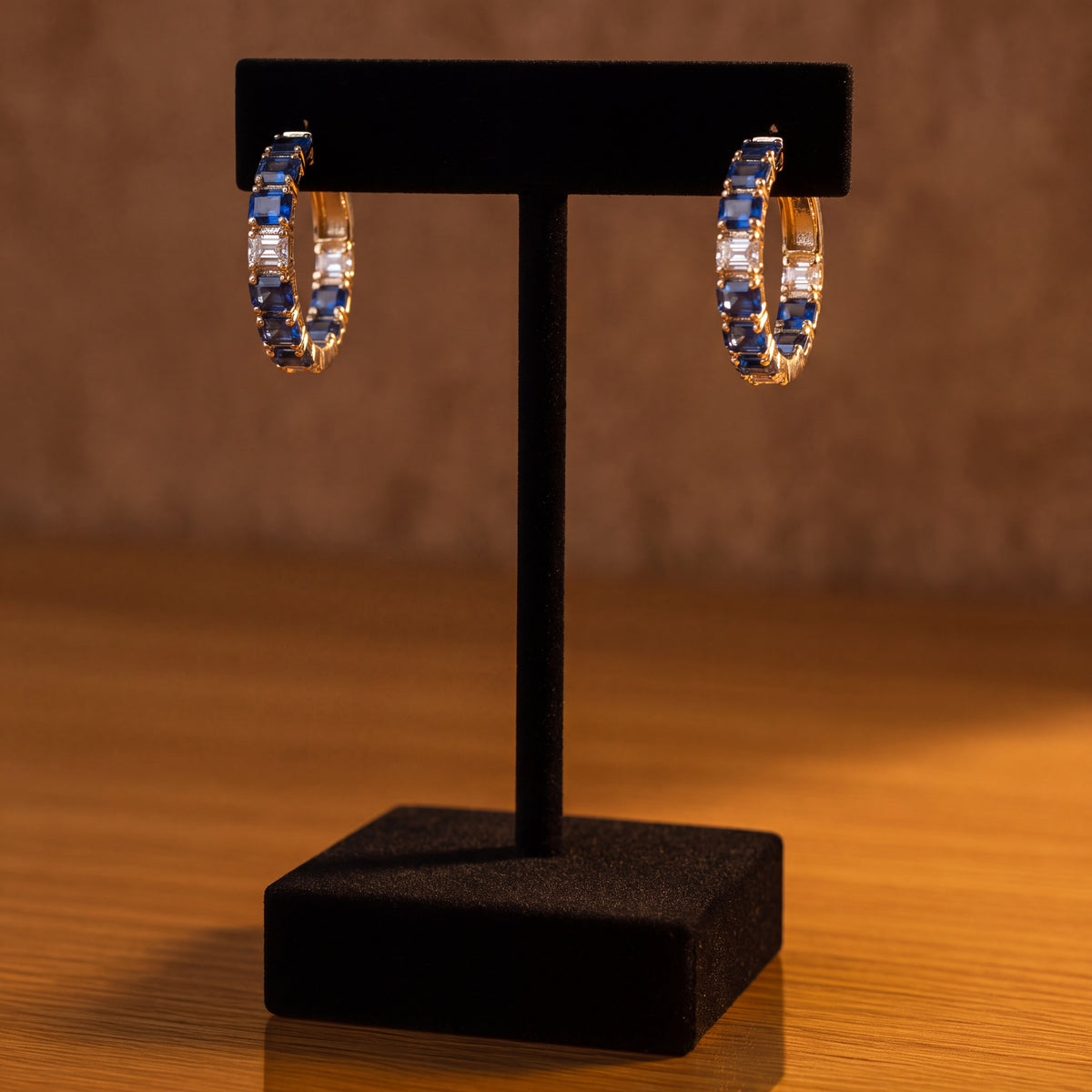 Yellow gold hoop earrings lined with blue sapphires