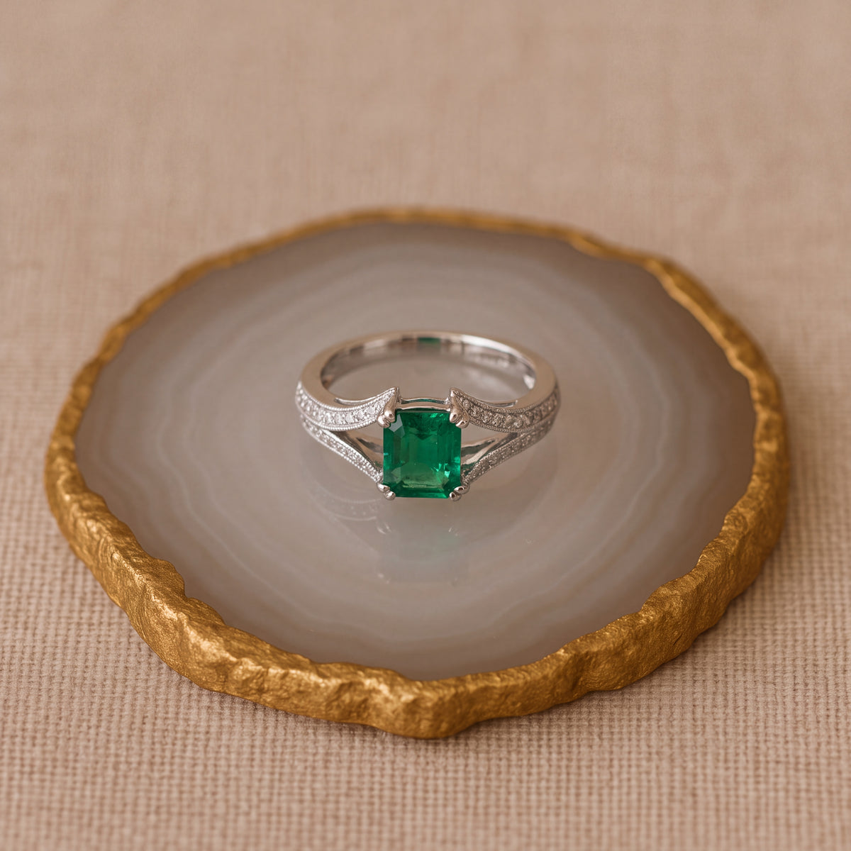 Emerald-cut emerald ring with a pavé diamond split-shank band in white gold