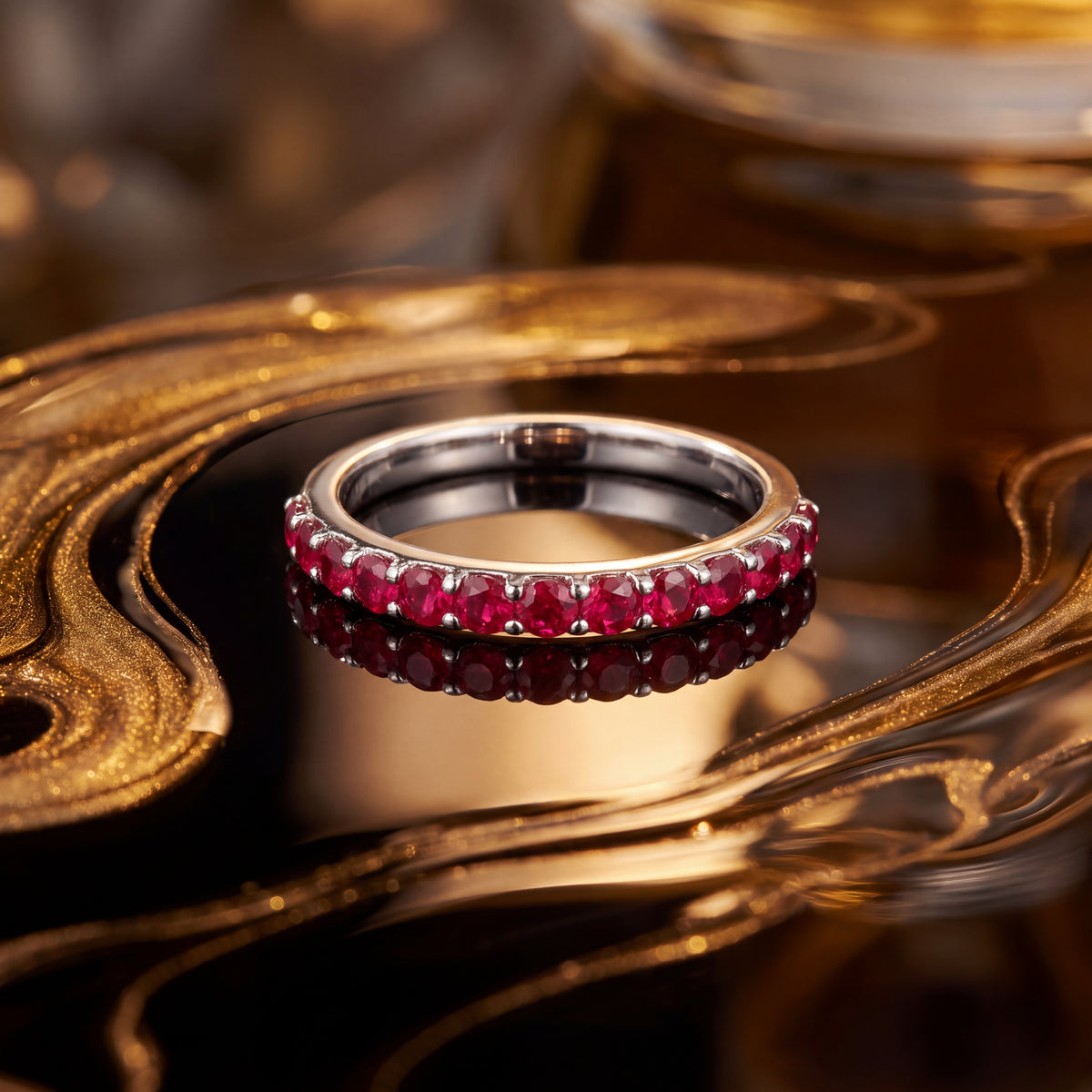 White gold band set with a row of round red rubies