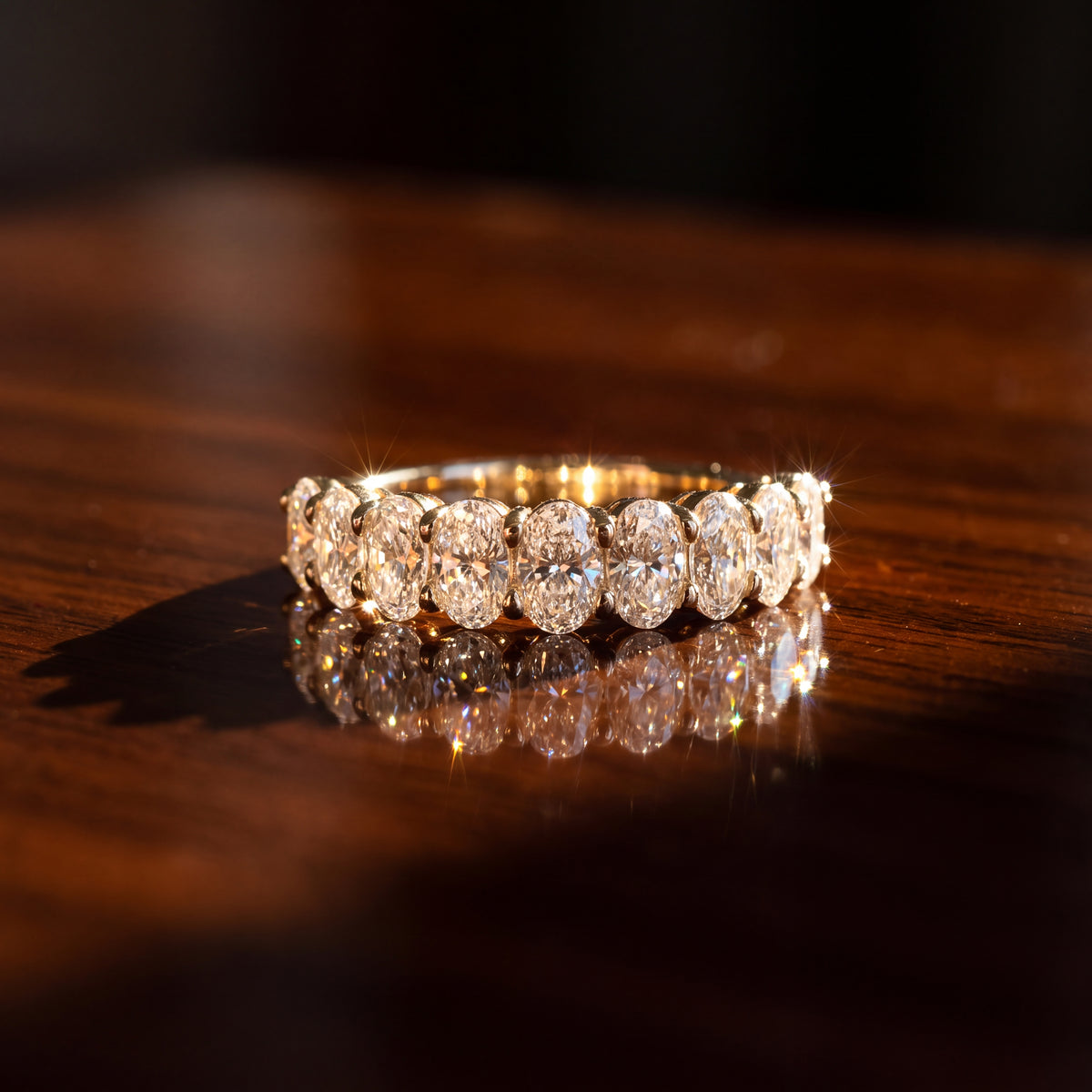 Yellow gold band of oval diamonds in shared prongs