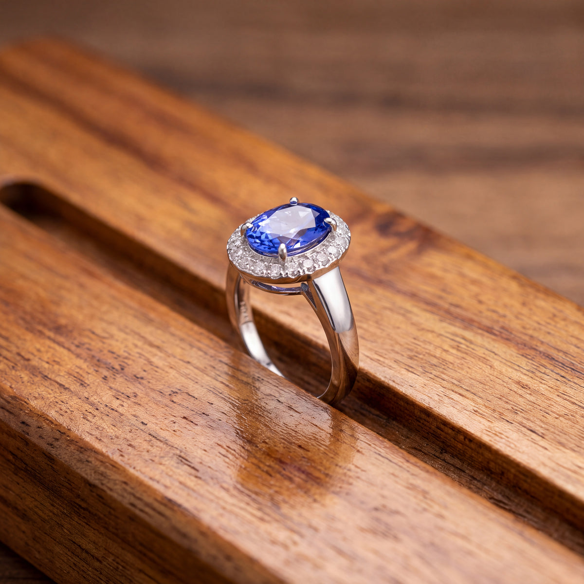 Oval tanzanite in a diamond halo on a smooth white gold band