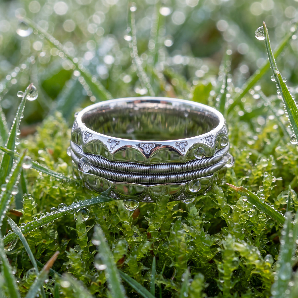 Wide white gold band with a cable center and scalloped diamond edges