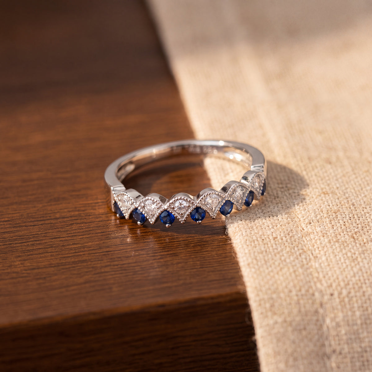 White gold band of sapphires and diamonds in a scalloped milgrain pattern
