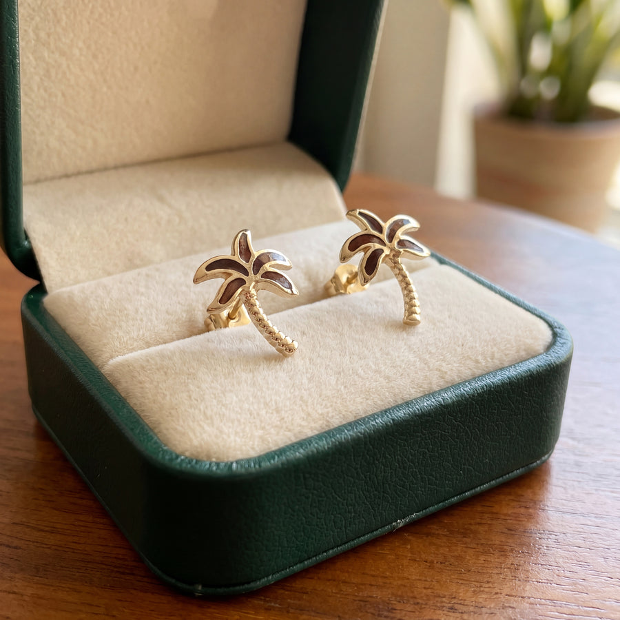 A pair of yellow gold palm tree stud earrings.