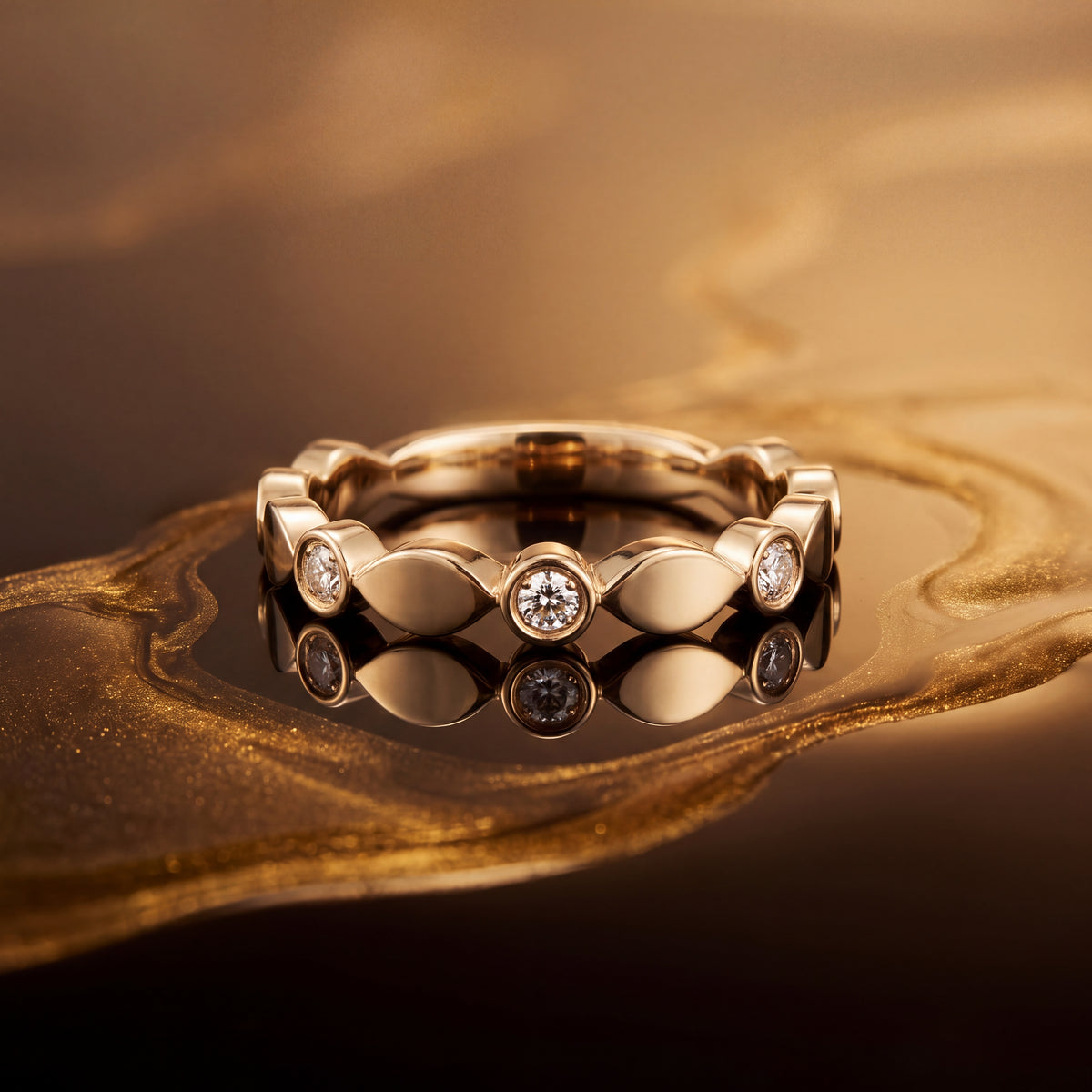 Yellow gold band of bezel-set diamonds alternating with leaf shapes