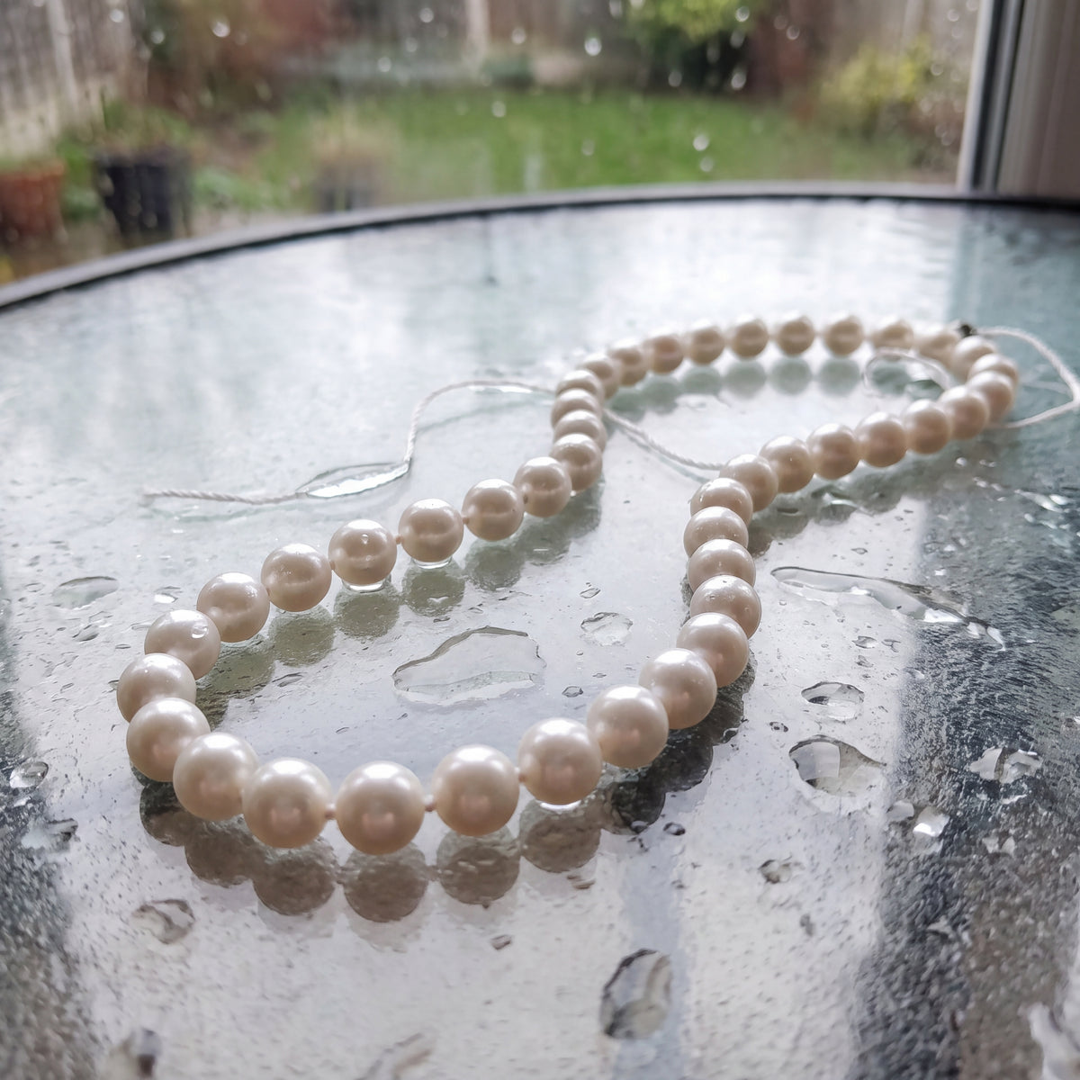 Strand of round white pearls with a yellow gold clasp