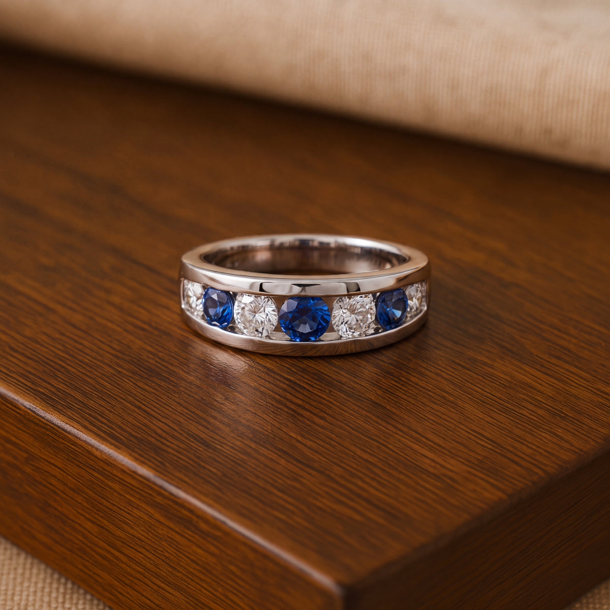 White gold band of round blue sapphires and white stones in a channel