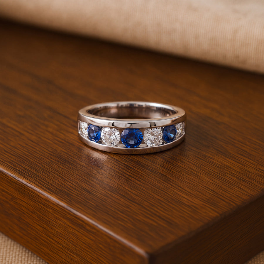 White gold band of round blue sapphires and white stones in a channel