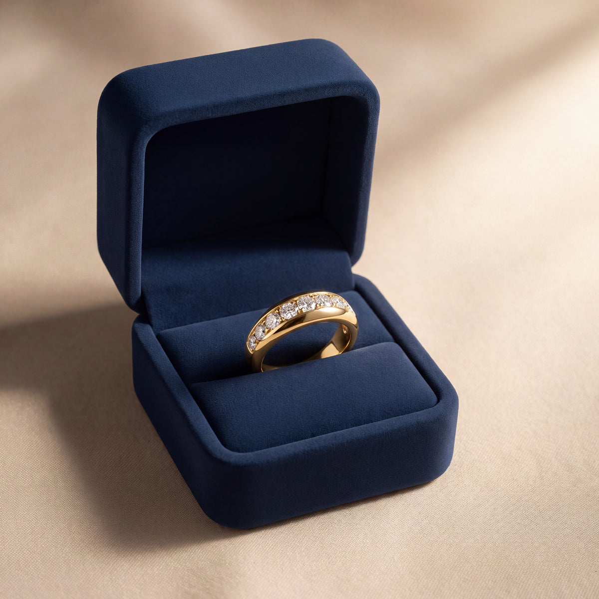 Domed yellow gold band with a row of pavé-set diamonds