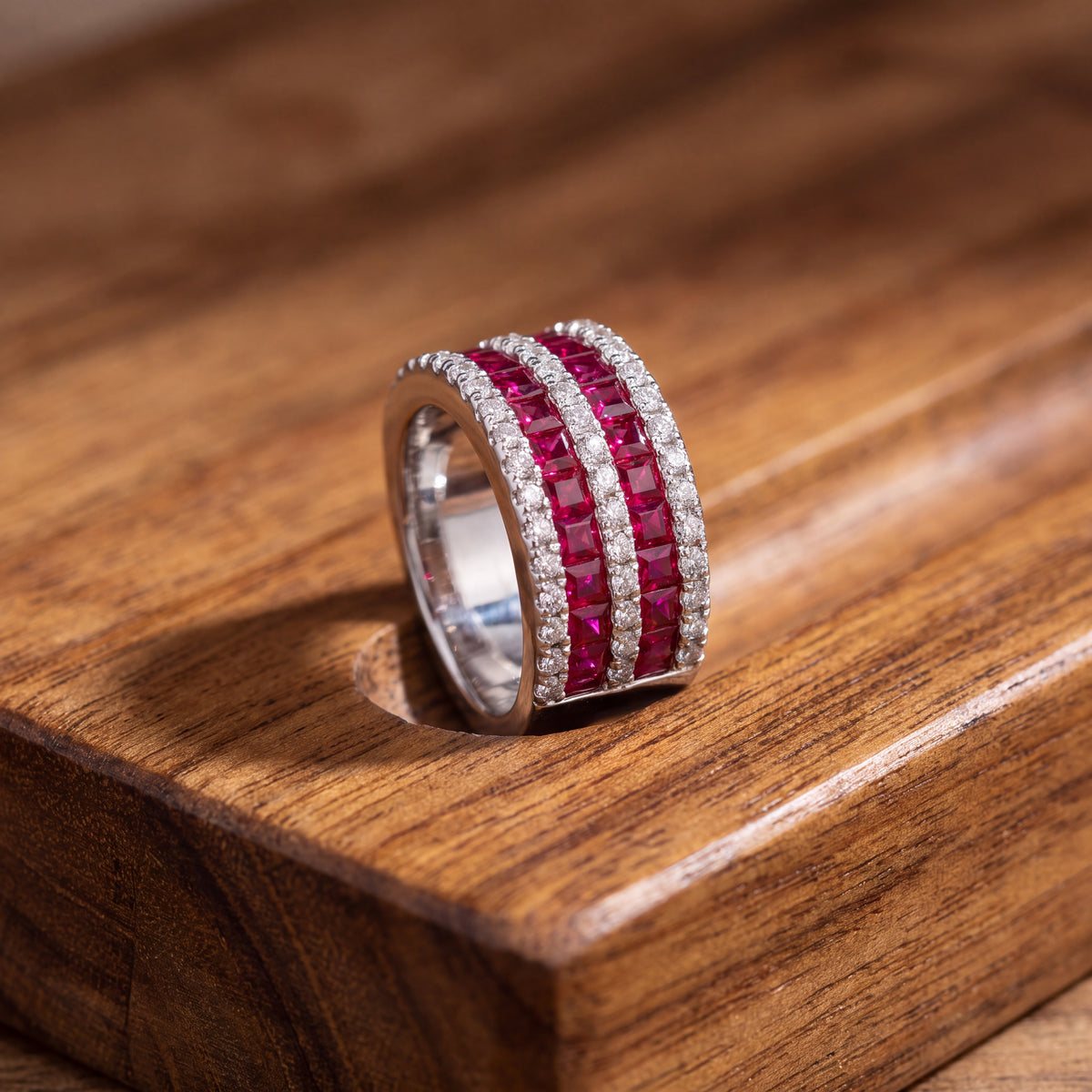 Wide white gold band with two rows of rubies between rows of diamonds
