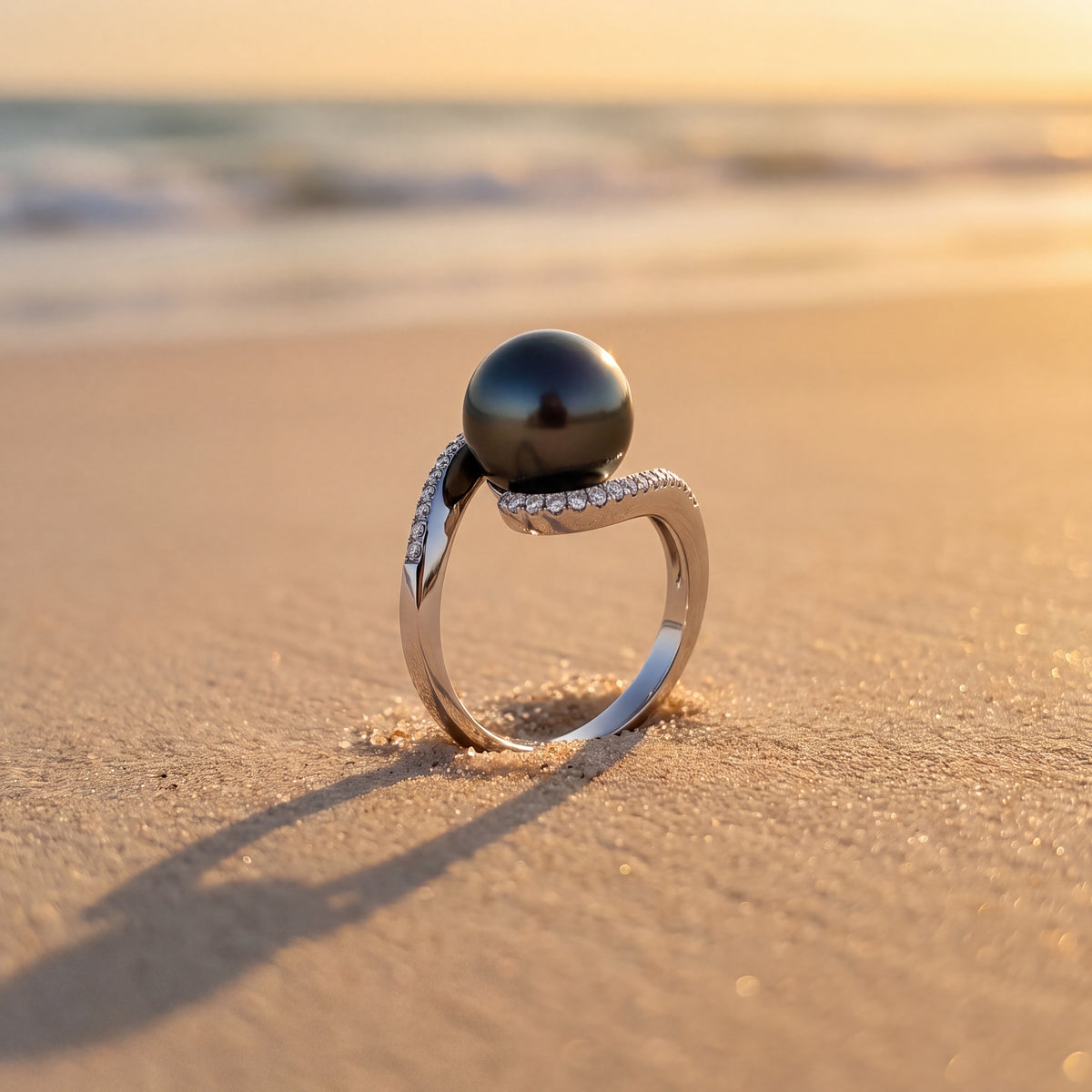 Bypass ring holding a dark pearl, its curves lined with pavé