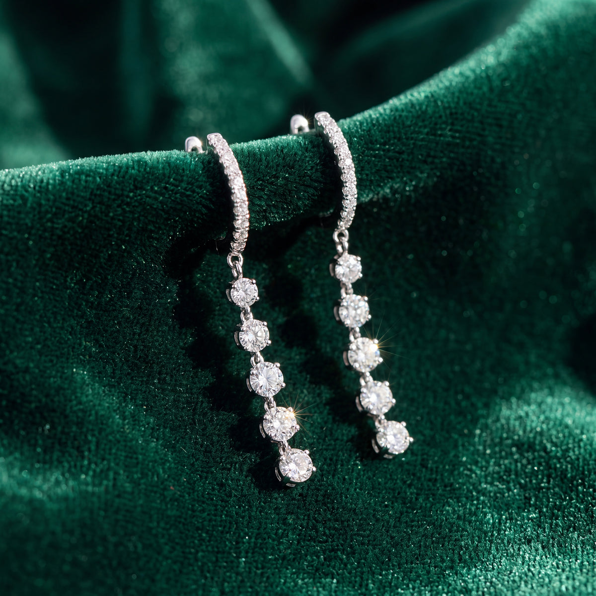 White gold drop earrings of round diamonds hanging from small hoops