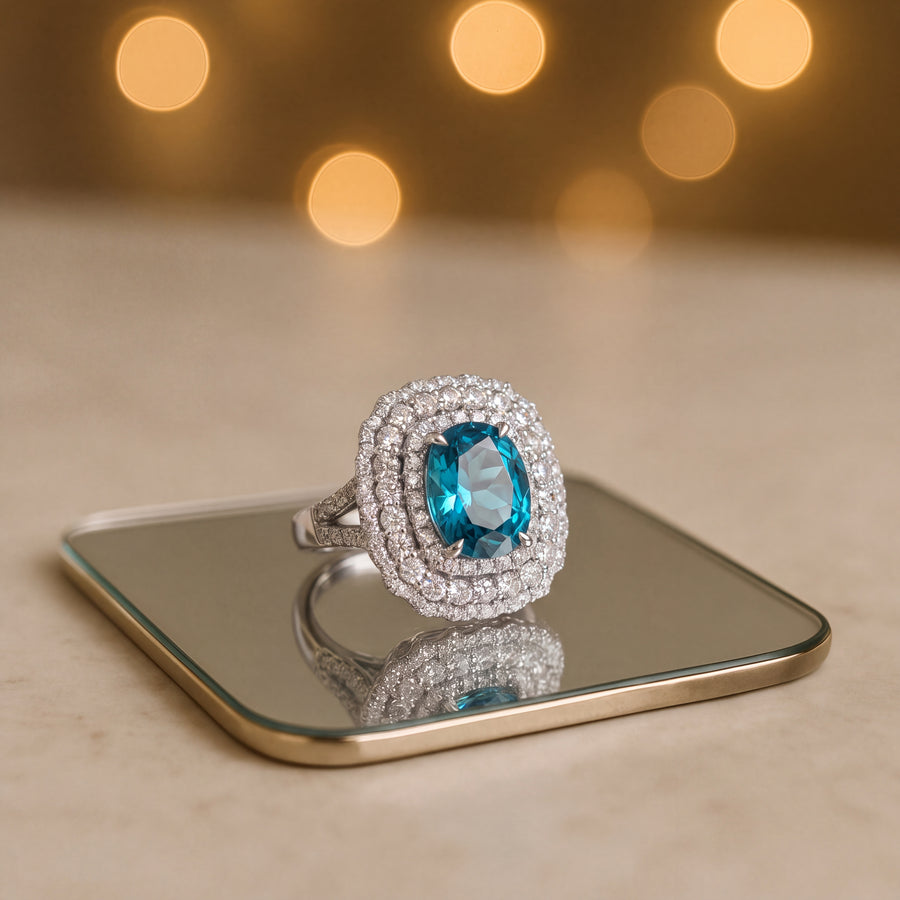 Blue zircon cocktail ring with a double diamond halo and diamond-set band in white gold