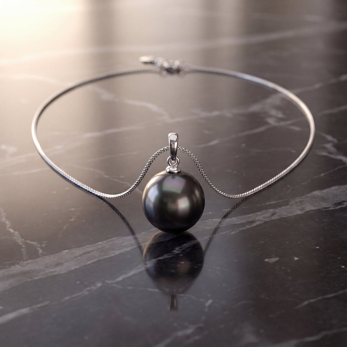 Single dark round pearl pendant on a white gold chain