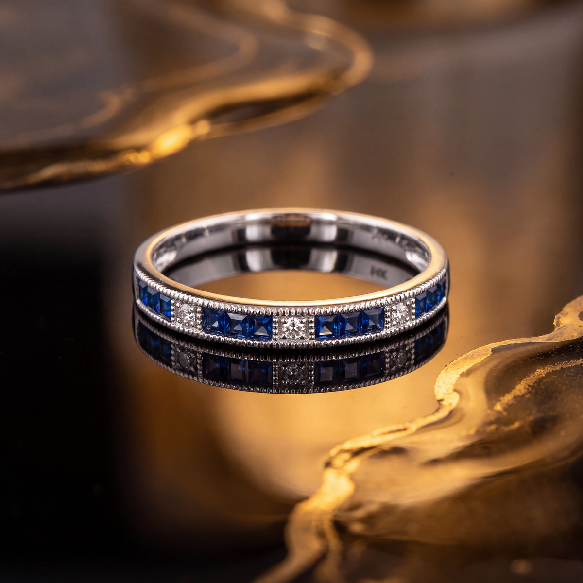 White gold band of channel-set blue sapphires and diamonds with milgrain