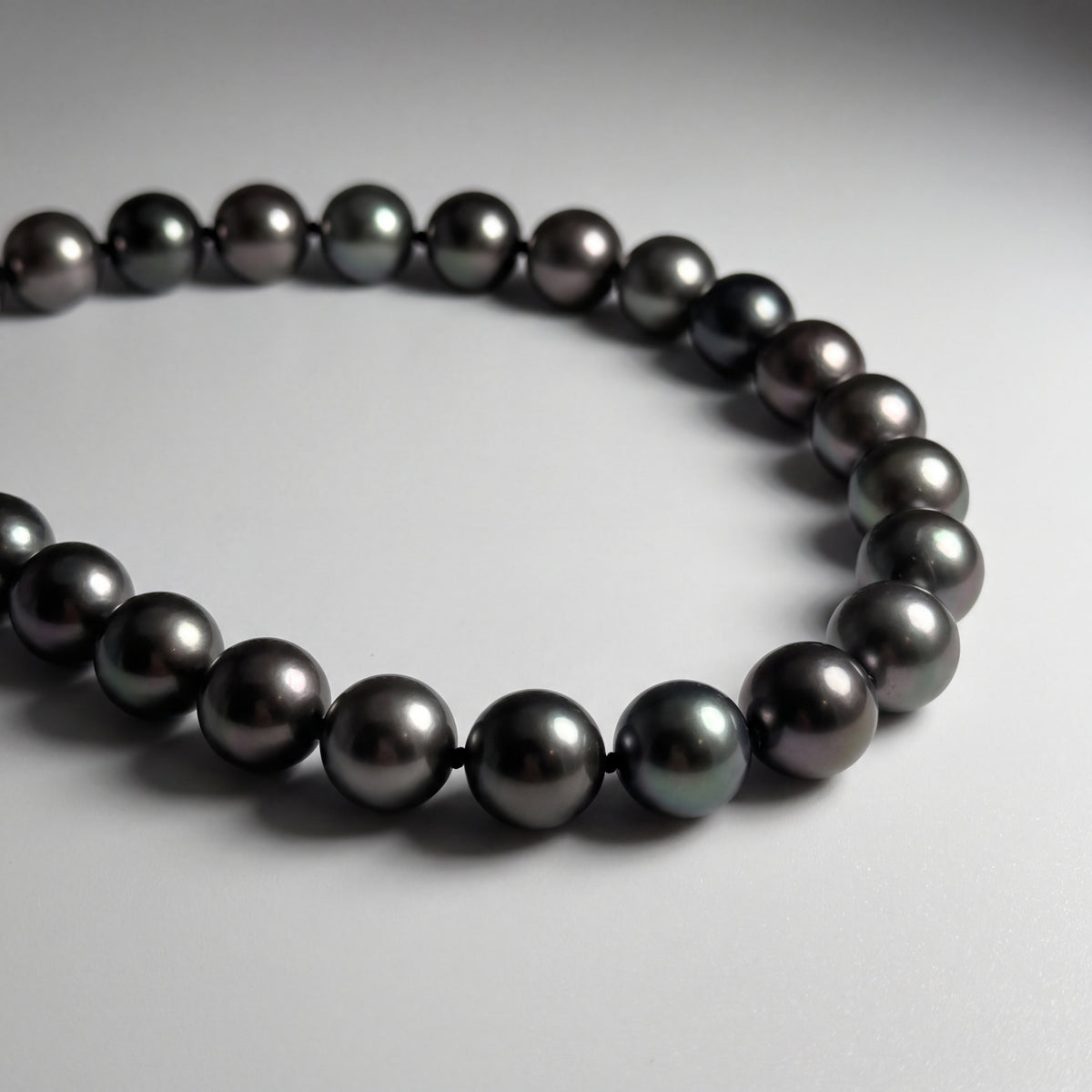 Knotted strand of dark round pearls