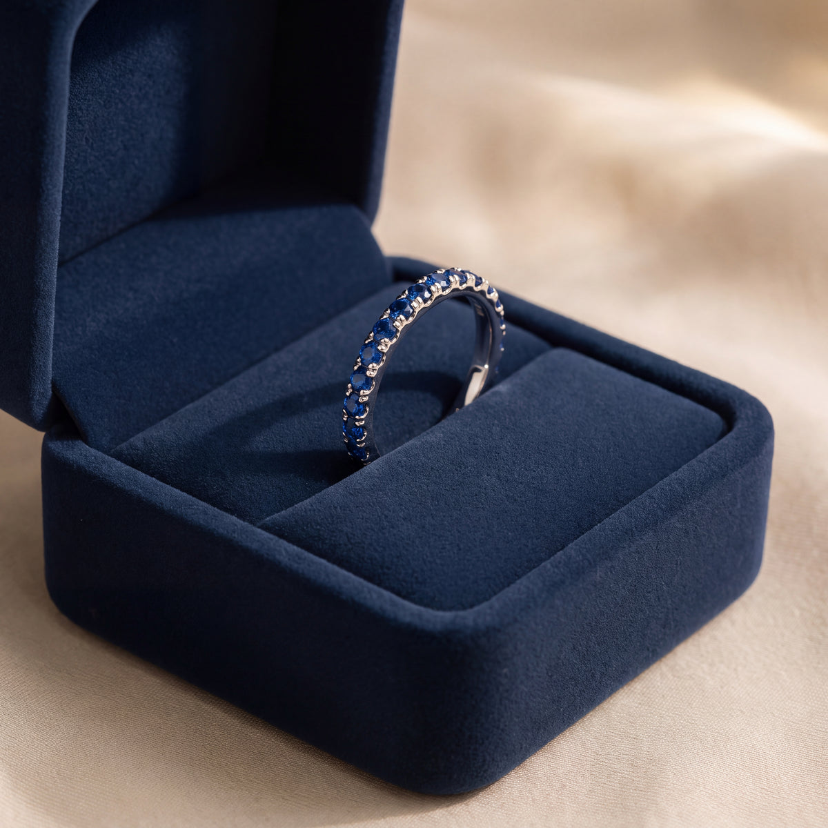 White gold band set with a row of blue sapphires