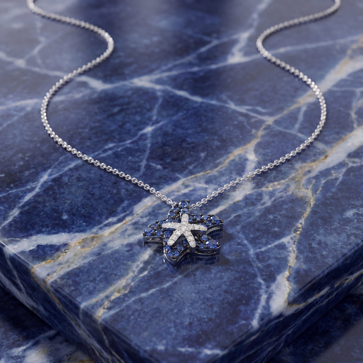 White gold double starfish pendant lined with blue sapphires