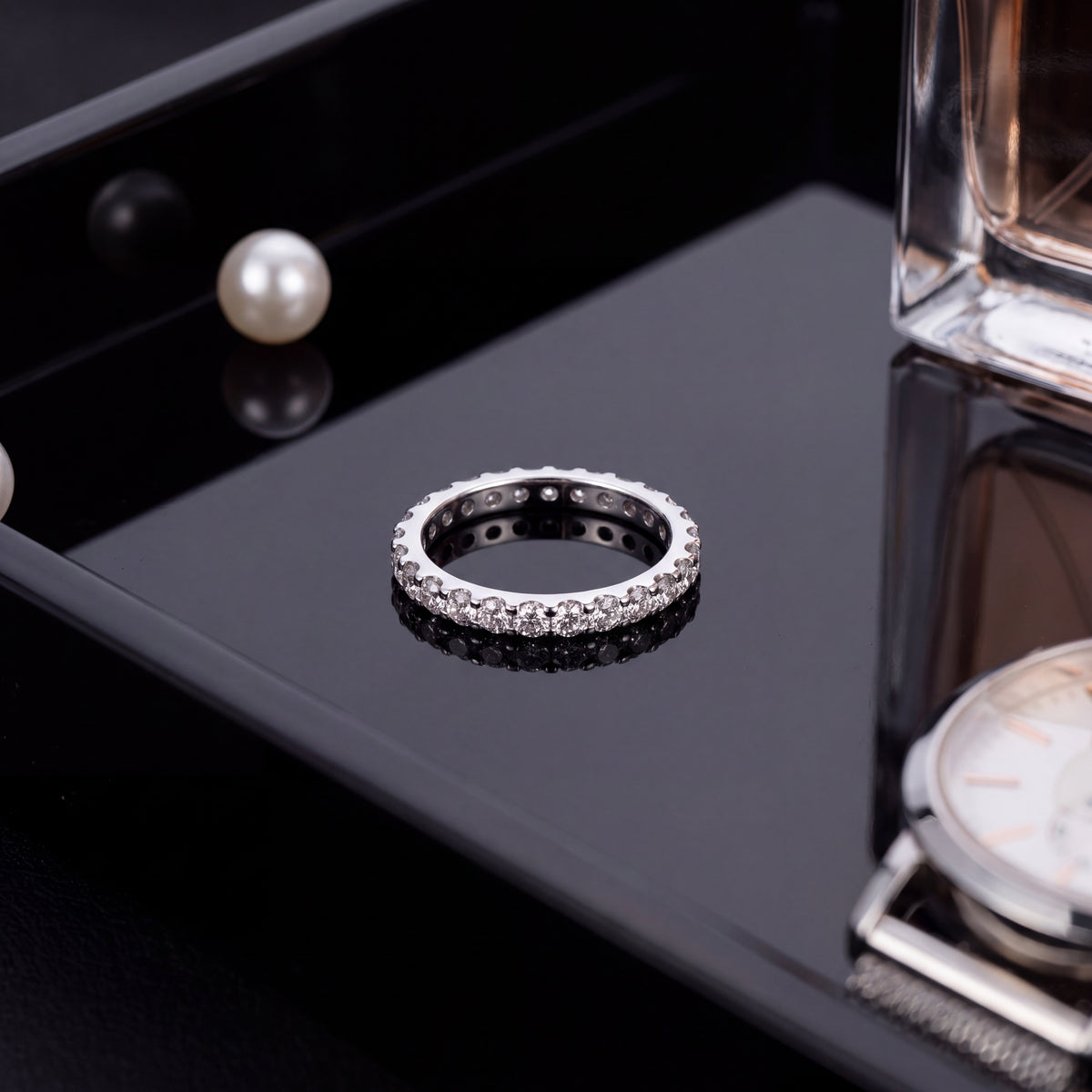Slender white gold eternity band with round diamonds in U-shaped shared prong settings