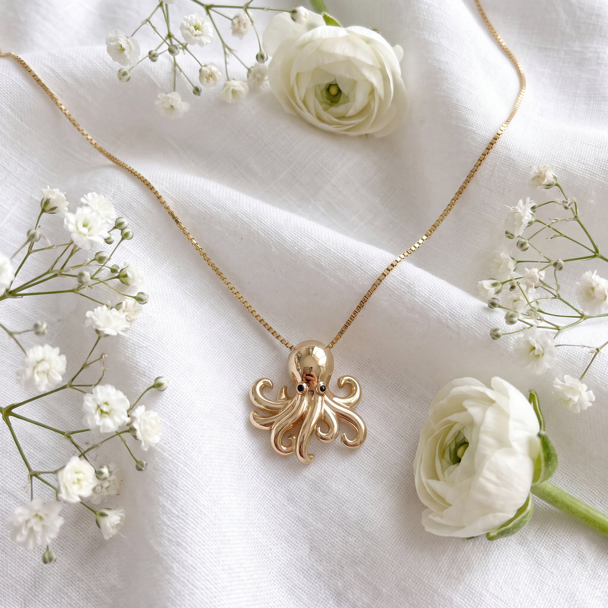 Yellow gold octopus charm with curling tentacles on a box chain