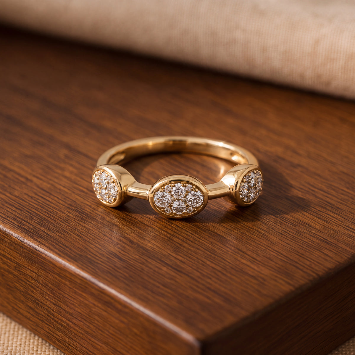 Slender yellow gold band with three oval pavé diamond clusters