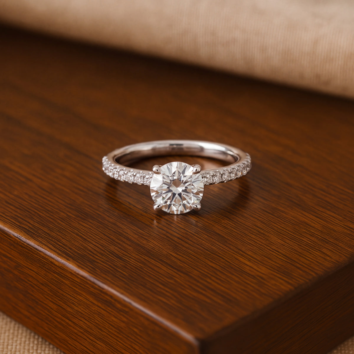 Round diamond engagement ring on a band with a row of pavé
