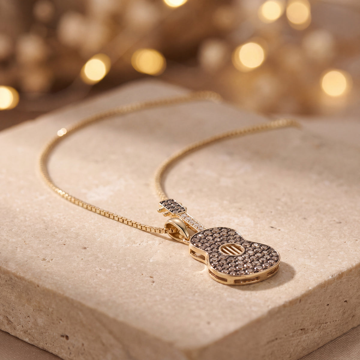Yellow gold guitar charm paved with brown stones on a box chain