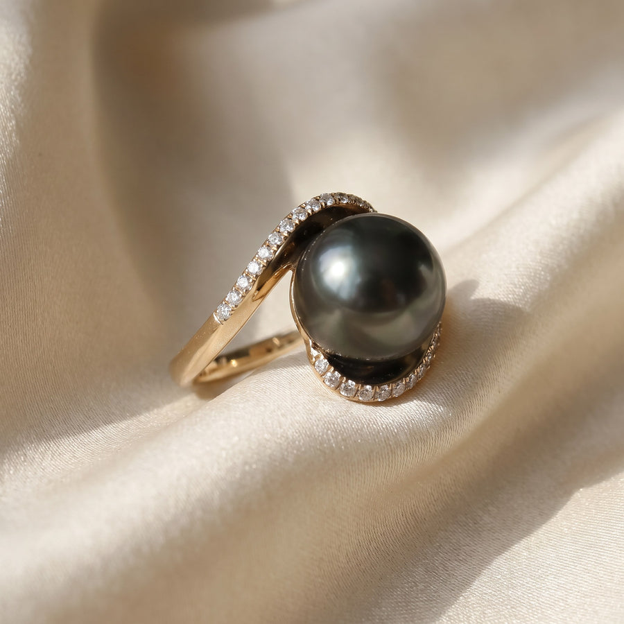 Black pearl in a yellow gold bypass ring with diamond-lined ends