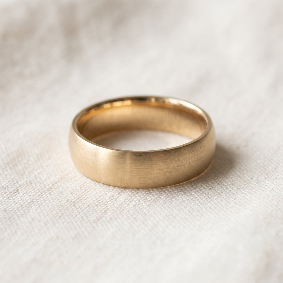 Brushed yellow gold band ring with a softly domed profile